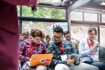 Audience using laptop, digital tablet cell phone in audience at technology conference