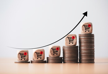 Increasing trend graph of sale volume with bigger shopping trolley cart on coins stacking for  online sale business and ecommerce growth concept.