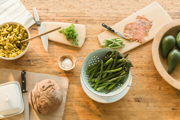 Overhead view lox, asparagus, pasta, bread and butter on dining table