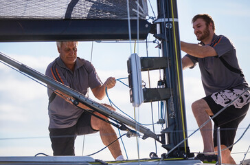 Men adjusting sailing equipment