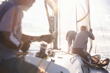 Fotobehang Zeilen Men adjusting sailing equipment on sailboat  © KOTO