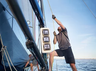 Fotobehang Man adjusting sailing equipment on sailboat © KOTO