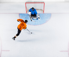 Hockey player shooting the puck at goal net