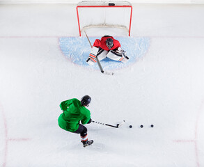 Overhead view hockey player practicing goalie shooting puck at goal net