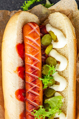 hot dog sandwich sausage, gherkin, ketchup, mayonnaise fast food smeal food snack on the table copy space food background rustic top view