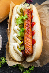hot dog sandwich sausage, gherkin, ketchup, mayonnaise fast food smeal food snack on the table copy space food background rustic top view