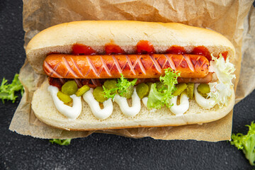 hot dog sandwich sausage, gherkin, ketchup, mayonnaise fast food smeal food snack on the table copy space food background rustic top view