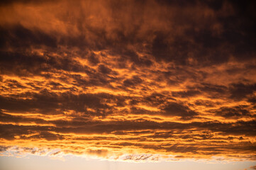Fototapeta premium warm golden hour sky with bright orange yellow clouds. Ideal for sky replacement in modern photo editing software tools, beautiful evening atmosphere
