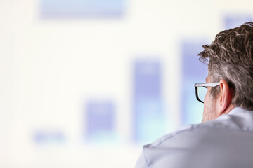 Businessman looking at bar chart on projection screen