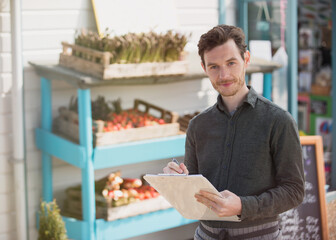 Portrait smiling farmer's market worker with clipboard