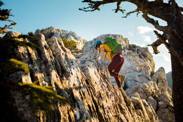 Woman climber with a backpack and a helmet in the mountains. A girl with a backpack walks along a mountain range. adventure and mountaineering concept. mountains of Turkey.