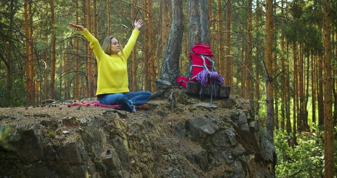 Breath of the forest and free your mind with meditation. Young woman start meditating in a morning pine forest. Solitude with your thoughts and nature. Nature as a path to mental health.