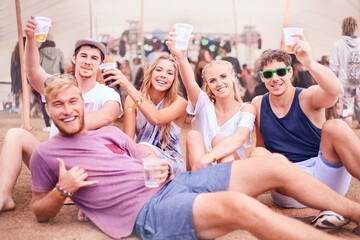 Portrait young friends with beer hanging out at music festival