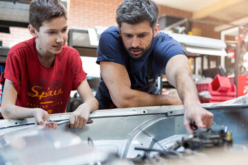 Father and son fixing car engine
