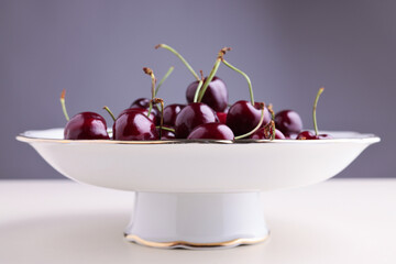 Ciliegie dolci, fresche e mature in primo piano, still life su fondo chiaro