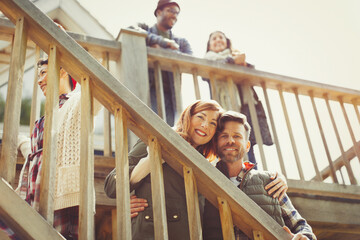 Portrait smiling couple on stairs outside cabin