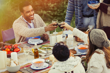 Couple toasting wine glasses at patio table lunch