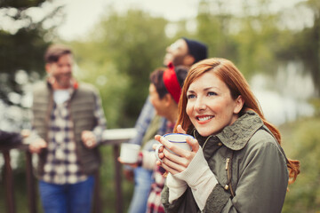 Smiling woman drinking coffee on balcony