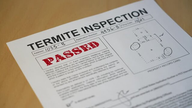 A closeup view of a termite home inspection is stamped PASSED. Data on form is fictional.  	