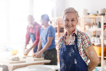 Portrait smiling senior woman in pottery studio - obrazy, fototapety, plakaty