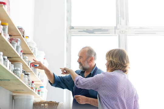 Man and woman browsing art supplies on shelves in art studio