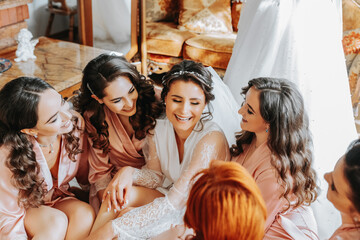 The bridesmaids look at the smiling bride. The bride and her fun friends are celebrating a...