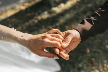 A beautiful luxury wedding. Close-up of bride and groom's hands. The groom holds the bride's hand. Wedding ring