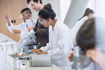 Female college students conducting scientific experiment in science laboratory classroom
