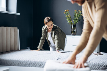 Couple buying new bed with orthipedic mattress in furniture store