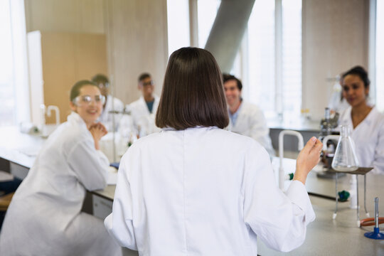 Female college student leading study group in science laboratory classroom - Powered by Adobe