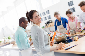 Portrait smiling woman enjoying cooking class in kitchen