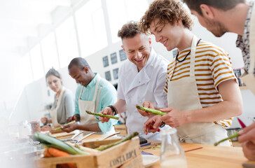 Chef teacher and students in cooking class kitchen