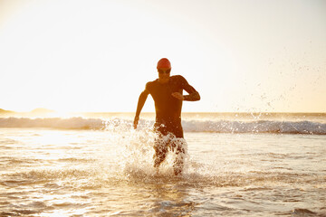 Fototapeta na wymiar Male triathlete running out of ocean