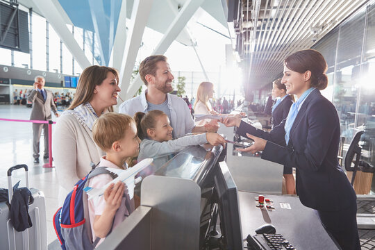 Customer service representative checking family tickets at airport check-in counter