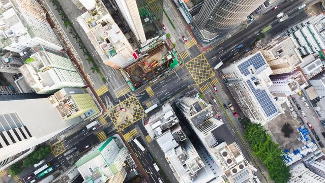 Hyperlapse time-lapse of car traffic on road junction intersection in Hong Kong city downtown. Drone aerial top view fly upward. Asian people lifestyle, Asia city life or public transportation concept