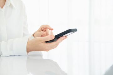 Hands of a woman who operates a smartphone
