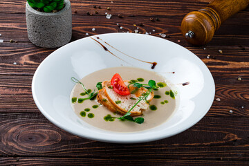Champignon cream soup with cherry tomatoes, microgreens and croutons, fresh meal.