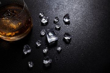 whiskey with ice on a wooden table. Reasonable consumption of alcoholic beverages