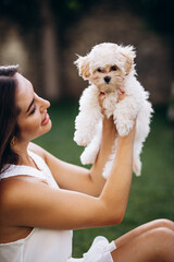 Beautiful woman holding her little maltipa dog
