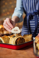 Sales Assistant In Bakery Putting Vegan Label Into Freshly Baked Savoury Roll