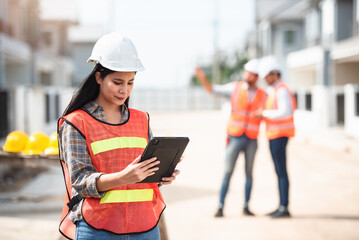 Construction worker, Engineering or architect woman using digital tablet for work at construction site , Engineer female inspection at real estate project.