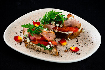Bruschettas with bacon, sweet pepper, blue cheese and arugula, appetizer.
