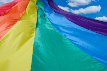 Fabric rainbow flag fluttering and going to sky. LGBT pride concept. pride month celebrates the...