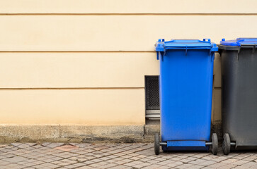Garbage containers near building wall in city