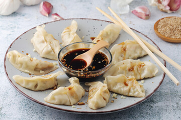 A plate of boiled jiaozi with dipping sauce