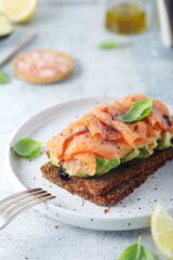A rye bread sandwich with avocado and salmon