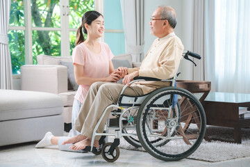 Fototapeta na wymiar Asian family health care and insurance business at home concept, woman daughter take care support to senior elderly father patient in wheelchair together, dad having smile in happy love lifestyle