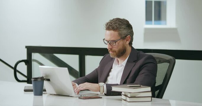 Office worker with laptop at office. Ofice employee remote working in modern office. Businessman have on line meeting. Business man using computer in office. Modern offices workplace.
