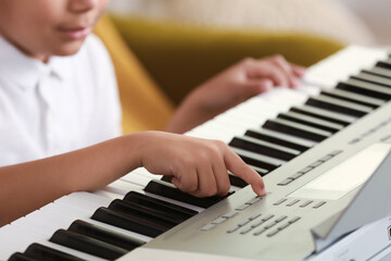 Fototapeta na wymiar Little African-American boy playing synthesizer, closeup