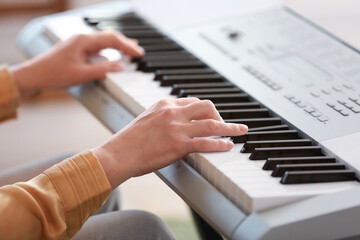 Fototapeta na wymiar Mature female musician playing synthesizer, closeup